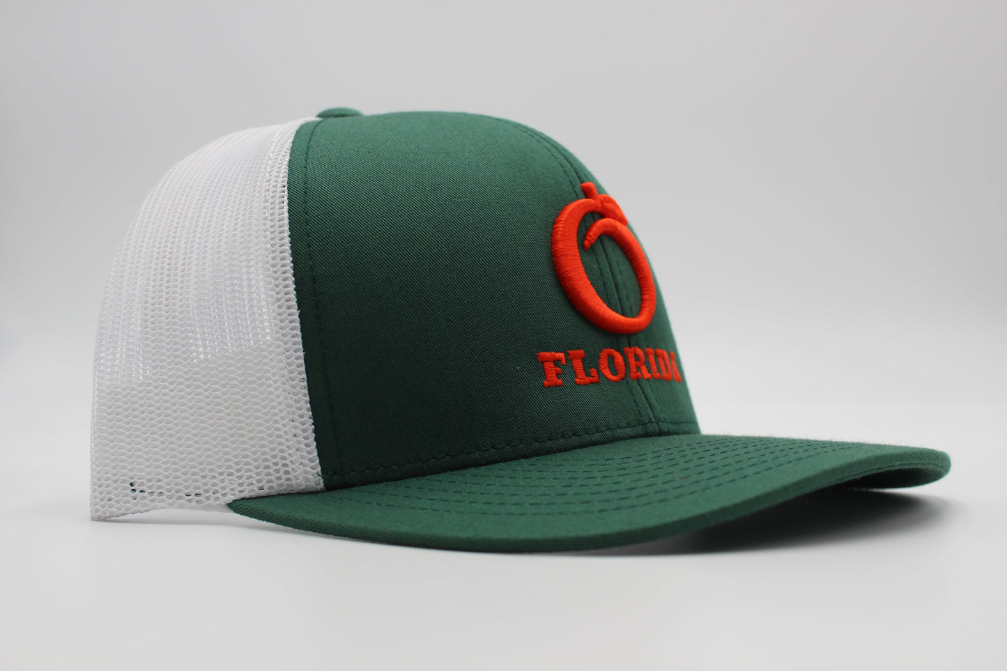 The Ridge Trucker Dark Green/White Orange logo